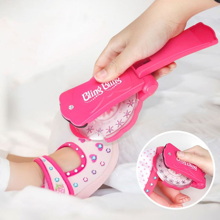 The Fashiongirl Bling Bling Ultimate Glam Kit features a pink handheld styling tool for adding sticky diamond stones to kids’ shoes. The kit includes 180 colorful gems and an inset shows the tool decorating a sparkling pink shoe.