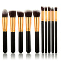 PRO Makeup Brush Set Black/Gold från PRO innehåller 10 premiumkabuki- och precisionsborstar med svarta handtag, guldfärgade hylsor och mjuka borst, alla upprättstående i rad mot en vit bakgrund för felfri applicering.