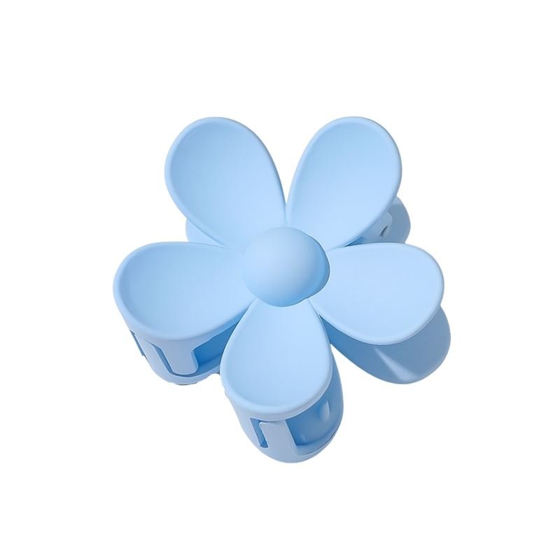 The SOHO Bloom Hair Claw in light blue features a smooth finish and rounded five-petal flower design, shown from above.