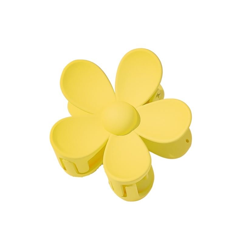 The SOHO Bloom Hair Claw - Yellow by SOHO is a blossom-shaped hair accessory with five rounded petals, shown from above on a white background.