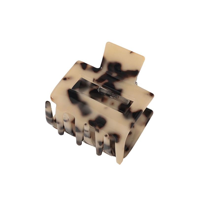 The SOHO Ema Hair Claw - Light Tortoise by SOHO features a beige and black tortoiseshell pattern, wide prongs, and a spring hinge—perfect for elegantly styling your hair.