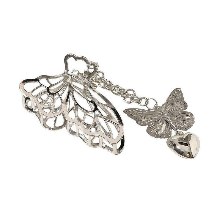 The SOHO Emy Metal Hair Claw - Butterfly features silver butterfly wings with chain-linked butterfly and heart charms. This detachable accessory by SOHO adds elegance and versatility to any hairstyle.