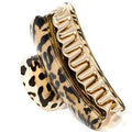 SOHO Hair Claw - Leopard från SOHO är en stor guld- och svartklämma med leopardmotiv, tillverkad av slitstark akrylplast och böjda tänder för ett säkert grepp.