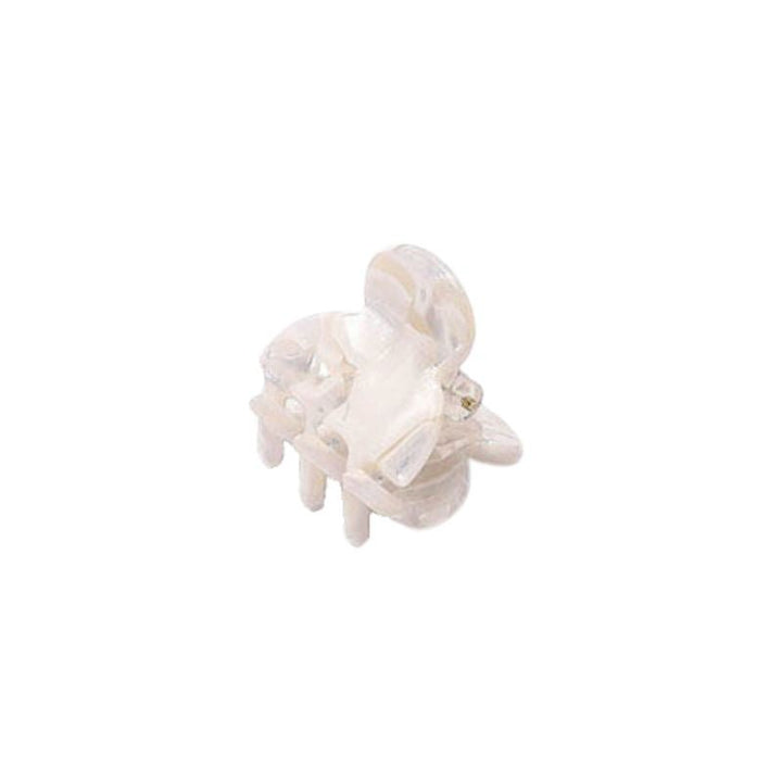 The SOHO Hara Mini Hair Claw - Porcelain by SOHO is a small, transparent plastic hair accessory resembling a mini claw, isolated on a white background.