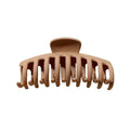 SOHO Kana Hair Claw - Beige har breda, böjda tänder för ett starkt grepp om alla hårtyper och avbildas mot en vit bakgrund.