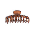 SOHO Kana Hair Claw - Tortoise är en stor brun plastklämma från SOHO med böjda tänder och ett fjädergångjärn, som ger ett starkt grepp för alla hårtyper och håller håret på plats.