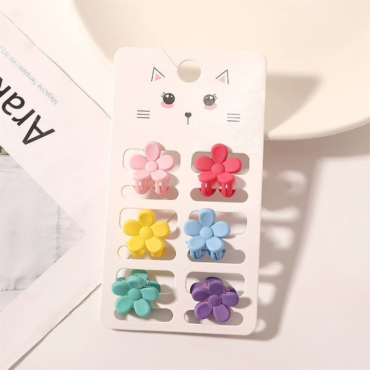 The SOHO Lala Mini Hair Claws - Flowers by SOHO feature six colorful, flower-shaped mini hair claws in pink, red, yellow, blue, green, and purple, displayed on a white card with a cute cat face illustration.