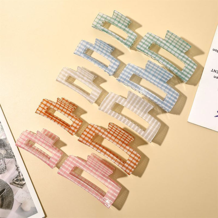 The SOHO Line Hair Claw - Green by SOHO adds a vibrant touch to any style. This secure-hold hair accessory, featuring a trendy checkered pattern, keeps your hair in place while offering standout style.