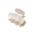 SOHO Loa Mini Hair Claw i vit marmor har en glänsande, pärlvit yta och en slät, böjd design med breda tänder, visad mot en enfärgad vit bakgrund.