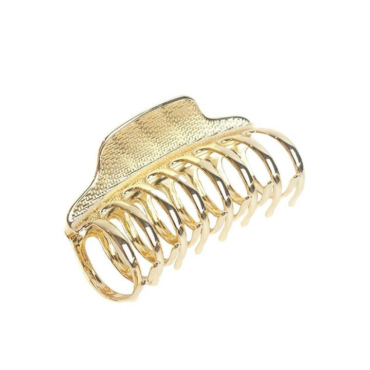 The SOHO London Metal Hair Claw in Gold features a textured top and curved interlocking prongs, offering a secure hold. Part of SOHO's stylish metal hair claws collection, it's an essential hair accessory.