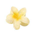 SOHO Moana Hair Claw - Yellow är ett ljusgult, blommformat håraccessoar från SOHO med fem glansiga kronblad och ett fjäderlås, inspirerat av plumeria-blomman – perfekt som sommaraccessoar.