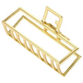 SOHO Niba Large Metal Hair Claw i guld har öppna stänger och ett fjädergångjärn som ger ett säkert grepp för slarviga knutar – perfekt för stilfulla, avslappnade looks.