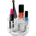 UNIQ Flower Makeup Acrylic Organiser - U301 från UNIQ har flera fack för förvaring av saker som rosa läppstift, en applikatorborste, orange läppglans, nagellack och en blå nagellacksflaska. Denna eleganta förvaringslåda sticker ut mot en vit bakgrund.
