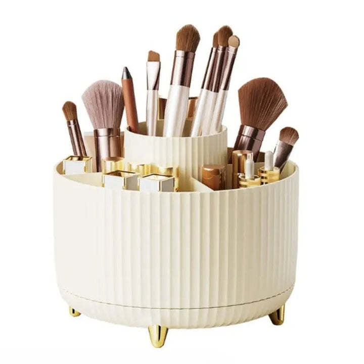 The UNIQ Rotating Makeup Organiser in Cream White features a tiered, ribbed design with compartments and gold legs, offering easy storage and organisation for brushes, lipsticks, pencils, and beauty products.