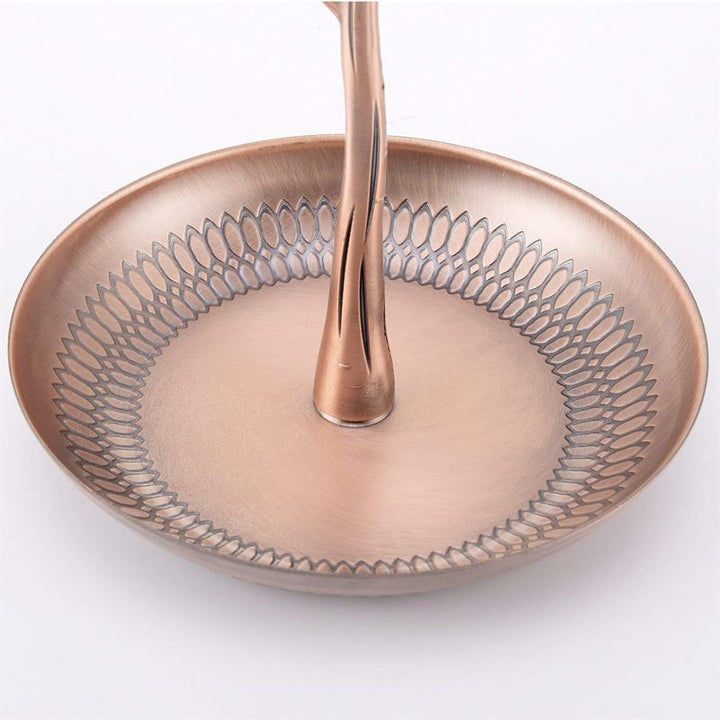 The UNIQ Bronze Vintage Jewelry Tree with 3 Birds is a round, bronze-colored metal organizer with a textured edge and central handle, featuring a shiny finish. This display stand is perfect for showcasing jewelry on any dresser.